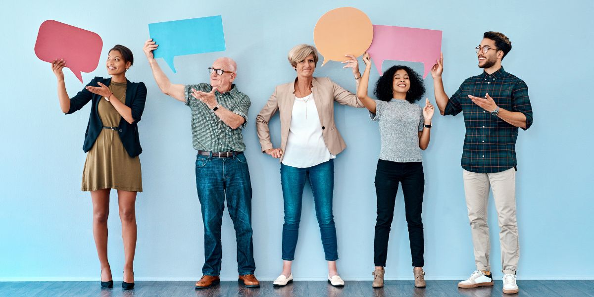 5 people from different ethnic backgrounds holding up empty speech bubble cards